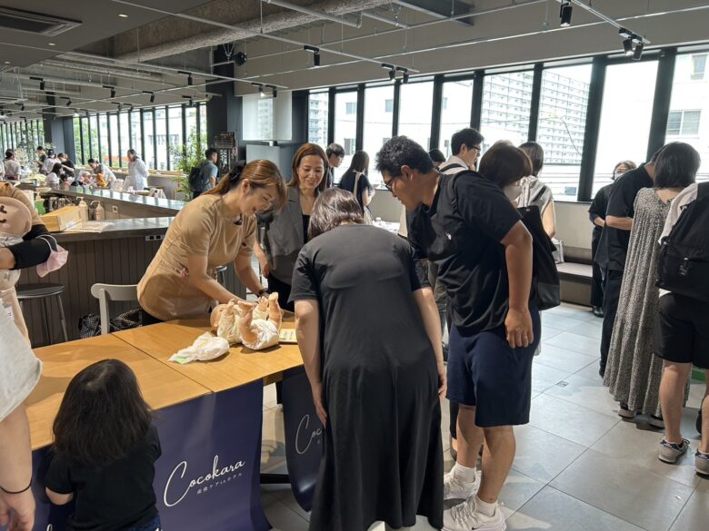 Cocokara札幌ホテル宿泊型産後ケアのブースでスタッフが来場者に説明している様子