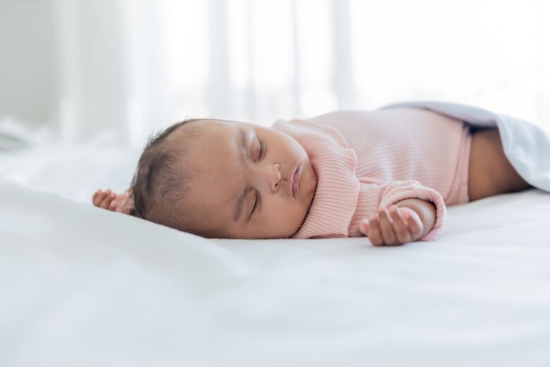 白いベッドで静かに眠る赤ちゃん