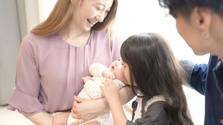 笑顔で赤ちゃんを抱いている様子